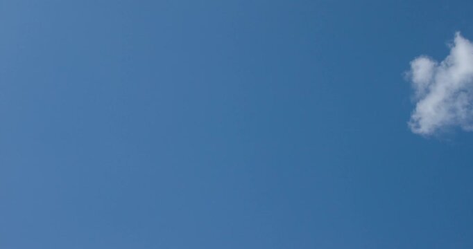 Timelapse of fluffy cumulus clouds drifting and changing shape across a vibrant blue sky. Perfect dynamic background for weather and nature concepts. 4K footage for your creative projects.