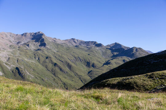 Beeindruckende Berglandschaft mit gr&uuml;nen H&auml;ngen und schroffen Gipfeln