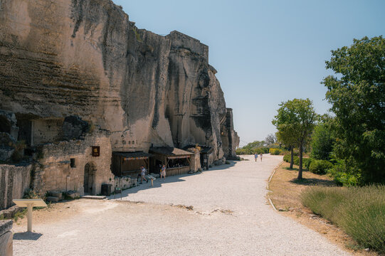 Falaise rocheuse aux Baux-de-Provence avec all&eacute;e pi&eacute;tonne et &eacute;choppes