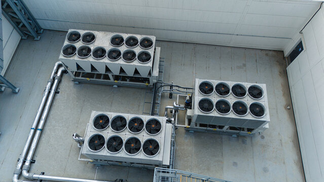 Aerial view of ventilation cooling units, heat exchangers and HVAC fans installed on a rooftop in Luton, England, United Kingdom.