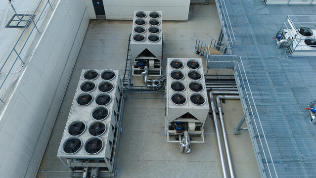 Aerial view of ventilation cooling units, heat exchangers and HVAC fans installed on a rooftop in Luton, England, United Kingdom.