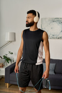 A handsome young african american man stands in relaxation, preparing for his workout at home.