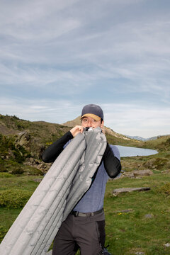 UGC Man blowing up sleeping pad with flash near Pyrenees lake