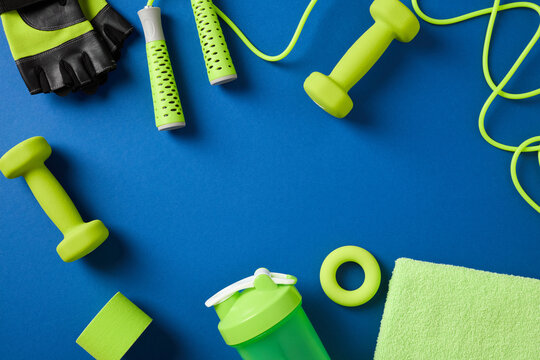 Green sports equipment frame on blue background with copy space.