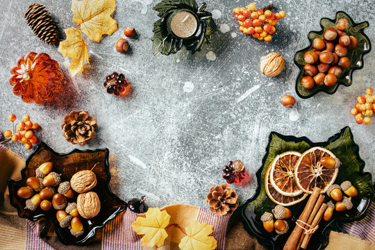 Autumn frame flat lay with nuts, spices and pumpkins om stone background.