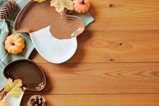 Mushroom ceramic plates and autumn decorations on wooden table. Flat lay, top view.