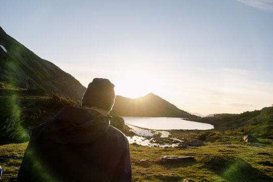 Man watching sunrise over alpine lake in the Pyrenees