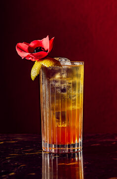 Sophisticated cocktail garnished with a red flower on a marble bar
