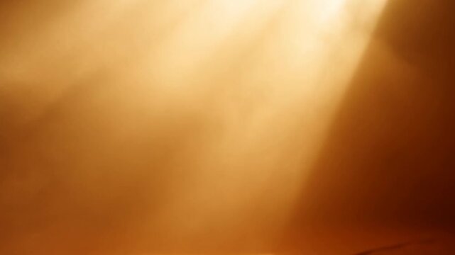 Warm golden light glowing through hazy orange atmosphere with soft rays and subtle illumination changes