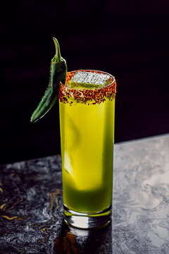 Spicy green cocktail with a chili powder rim and green pepper garnish