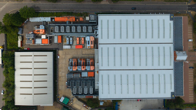 Aerial view of a data center facility featuring large industrial cooling units, rooftop ventilation systems, and expansive warehouse structures in Hemel Hempstead, England, United Kingdom.