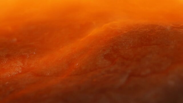 Orange pumpkin flesh close up showing fibrous moist texture with small droplets