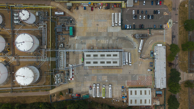 Aerial view of Buncefield LPG Terminal with large white storage tanks, industrial buildings, and a parking area with trucks and cars in Hemel Hempstead, England, United Kingdom.