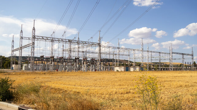 Subestaci&oacute;n el&eacute;ctrica en un campo seco bajo un cielo azul con nubes