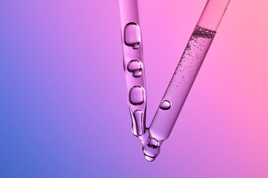 Glass pipettes with liquid on gradient pink and purple background.