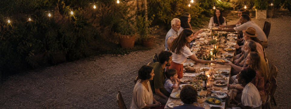 Community dinner with friends and family at a long outdoor table