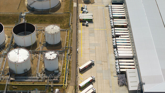 Aerial view of the Buncefield Oil Depot and distribution centre showing large white storage tanks and a busy loading bay with numerous HGVs in Hemel Hempstead, England, United Kingdom.