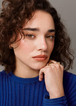Woman Poses With Hand on Chin in Studio Setting