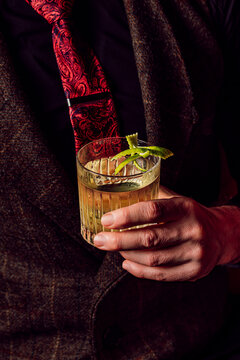 Close-up of an elegant man holding a classic cocktail