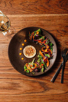 Top-down shot of an artistic circular salad around a central dip