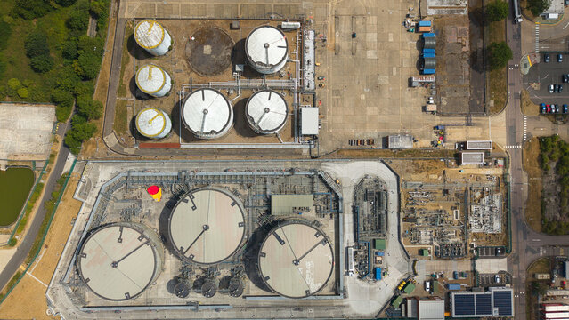 Aerial view of the petroleum oil terminal and LPG storage facility with large circular storage tanks, industrial piping, and paved grounds in Hemel Hempstead, England, United Kingdom.