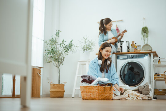 laundry music women with home lifestyle; friends sorting laundry with music. laundry guides buyer choices, music frames the scene, and women adds useful meaning. In a clear visual scene.