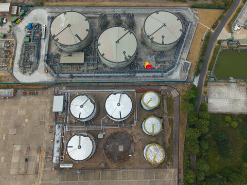 Aerial view of a petroleum oil terminal with large industrial storage tanks, complex piping systems, and paved grounds in Hemel Hempstead, England, United Kingdom.