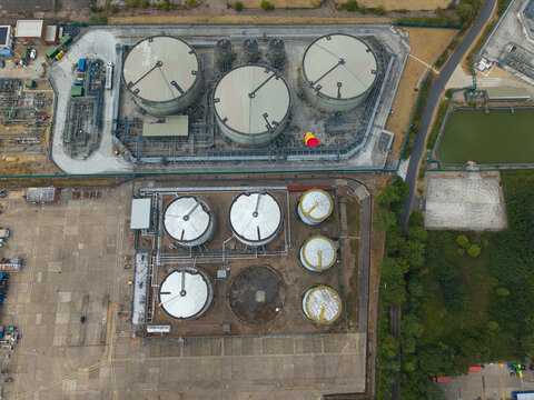 Aerial view of a petroleum oil and LPG terminal featuring large industrial storage tanks, complex piping networks, and paved service areas in Hemel Hempstead, England, United Kingdom.