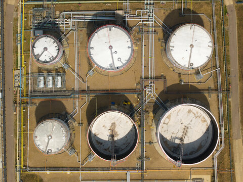 Aerial view of petroleum oil terminal with large circular storage tanks and complex network of pipelines in an industrial facility in Hemel Hempstead, England, United Kingdom.