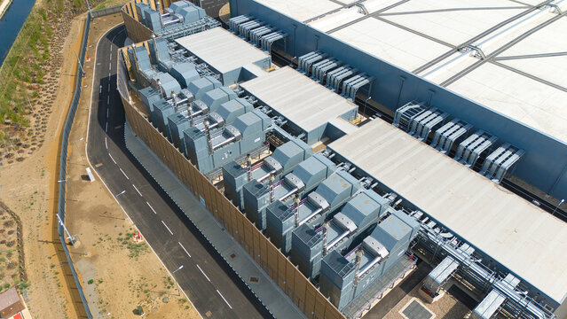Aerial view of a hyperscale data center rooftop featuring rows of industrial air handling units and chillers for cooling infrastructure in Hereford, England, United Kingdom.