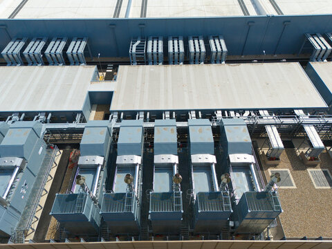 Aerial view of a hyperscale data center featuring rows of air handling units and industrial chillers on the roof in Hereford, England, United Kingdom.