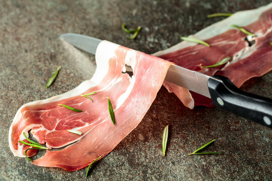 Delicious prosciutto slices topped with fresh rosemary.