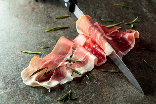Delicious prosciutto slices topped with fresh rosemary.