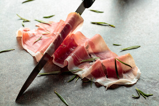 Delicious prosciutto slices topped with fresh rosemary.