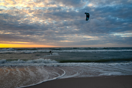 Kiteboarding sportsman rider with his kite in sea