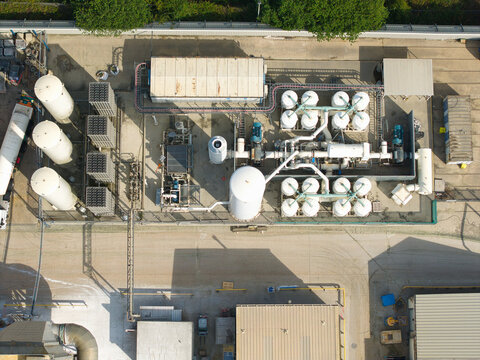 Aerial view of industrial cryogenic storage tanks and gas vaporization systems at a glass manufacturing facility in Harlow, England, United Kingdom.