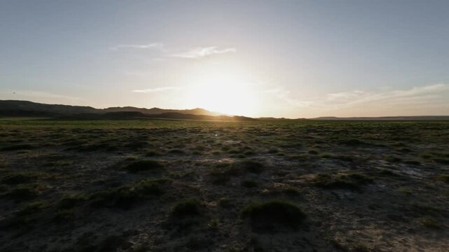 Scenic view from SUV driving through open landscape at sunset, mountains ahead