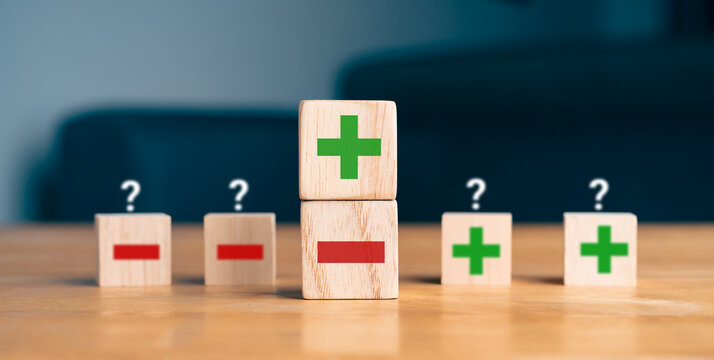 Pros and cons decision making concept with green plus and red minus symbols on wooden blocks
