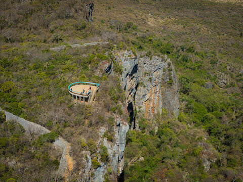 Aerial view of the French Mountain lookout point, featuring a curved observation deck on a rocky cliff edge, surrounded by lush vegetation and rugged terrain in Antsiranana, Diana, Madagascar.