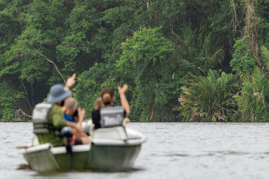 Family enjoying a boat ride exploring tropical rainforest