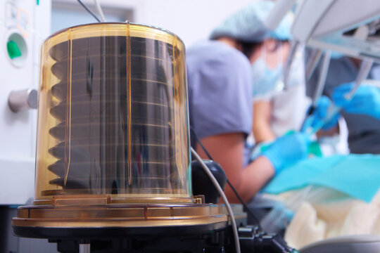 Surgery under anesthesia. Anesthesia machine. Work of surgical teams visible in background. Clinical equipment and surgical surgery