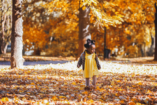 Little girl running freely down an autumn forest path