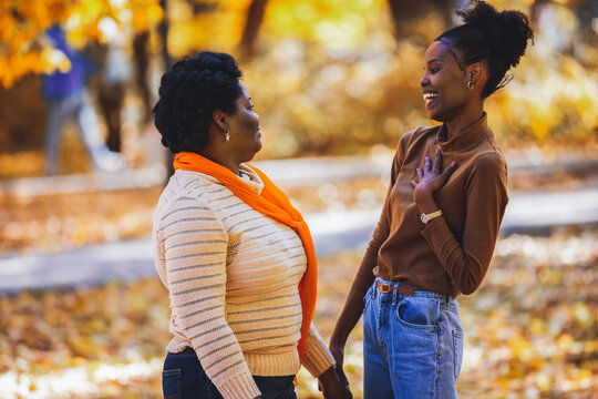 Warm smiles shared between mother and daughter outdoors