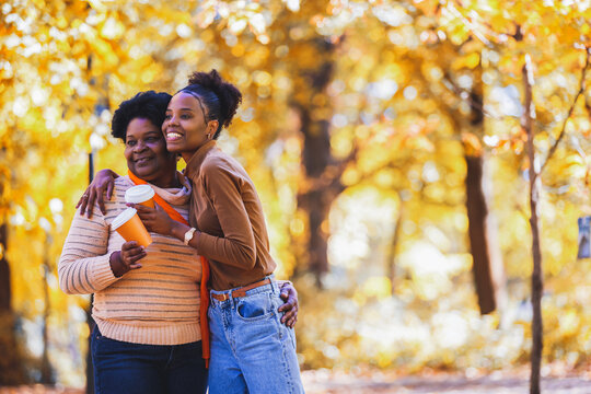 Joyful embrace of a mother and daughter with coffee