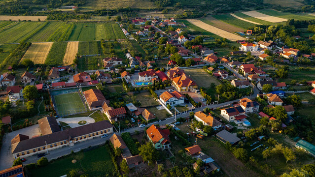 Aerial view of residential houses, agricultural fields, and a sports court in Deva, Hunedoara, Romania.