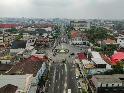 Aerial view of Tugu Yogyakarta Monument surrounded by city streets, traffic, and historic buildings under an overcast sky in Yogyakarta, Special Region of Yogyakarta, Indonesia.