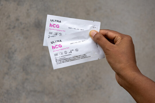 Kishoreganj, Bangladesh - 12 August, 2026 - Hand holding two packets of ULTRA hCG One Step Pregnancy Test kits. Medical diagnostic test product by SD Biosensor.