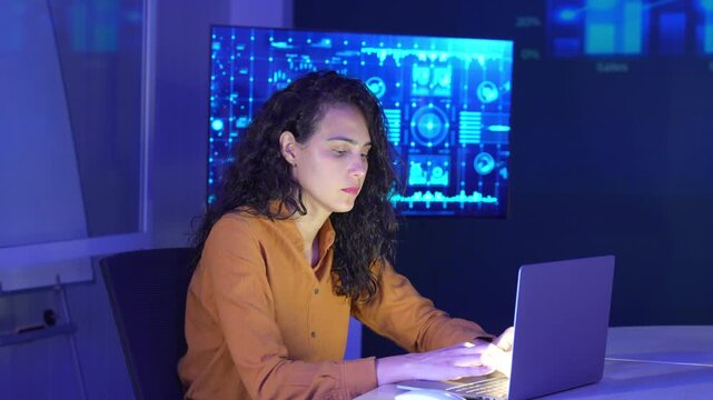 Businesswoman working on a laptop in a modern technology workspace with a digital interface displayed on a background. data analytics, innovation, cybersecurity, and modern workplace solutions.