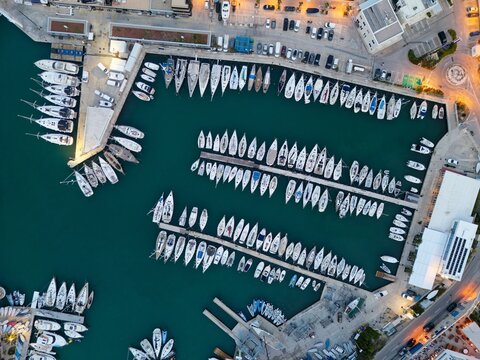 From above, Split&rsquo;s marina reveals orderly piers stretching into emerald waters, where white yachts rest in rhythmic rows, framed by harbor streets, cars, and buildings highlight the city&rsquo;s vibrant  