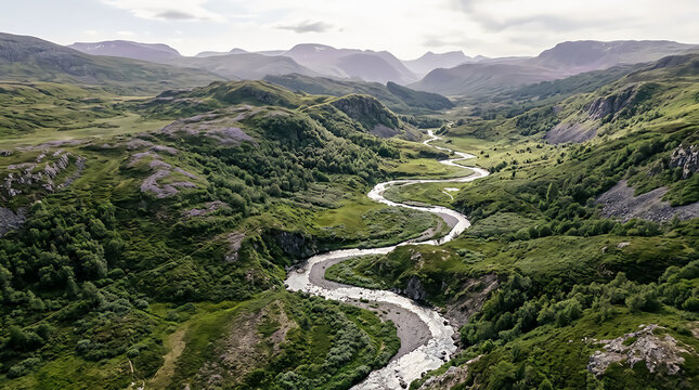 Winding river flowing through a deep green valley surrounded by large rocky mountain peaks